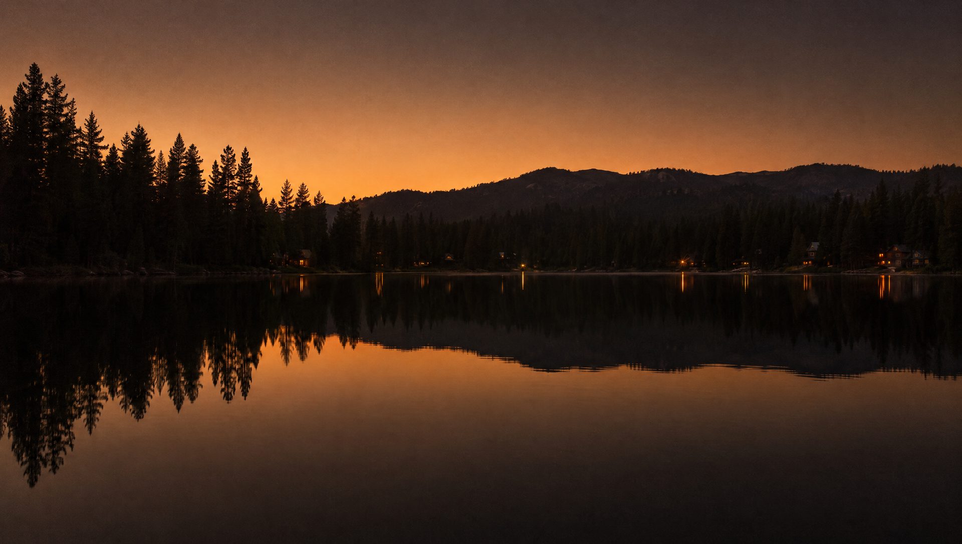 Bass Lake at last light, still water and dark pine shoreline